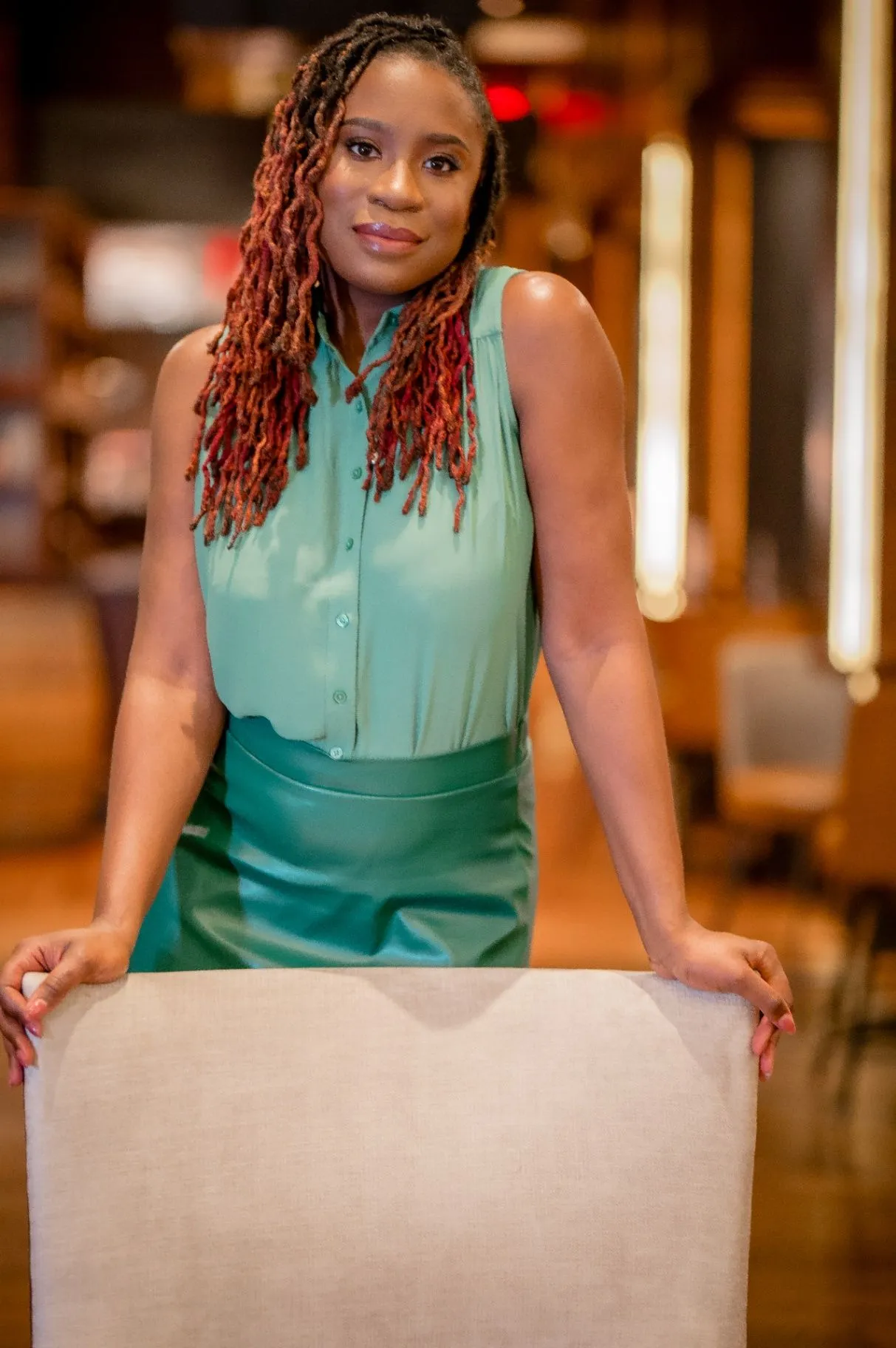 Atiya S. Brown standing behind a table and smiling at the camera